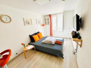 Una sala de estar con un sofá y un reloj en la pared. en JOLI STUDIO HYPER CENTRE TRES PROCHE VIEUX PORT, en Marsella