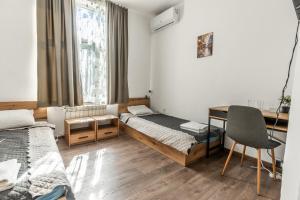 Una pequeña habitación con dos camas y un escritorio. en Vitoshka Inn - R3, en Sofía