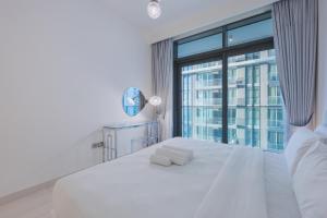 a bedroom with a white bed with a large window at Sea View with Private Beach Access! 3BR & Maid Rm in Dubai +58 photos