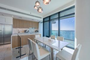 a kitchen and dining room with a table and chairs at Sea View with Private Beach Access! 3BR & Maid Rm in Dubai