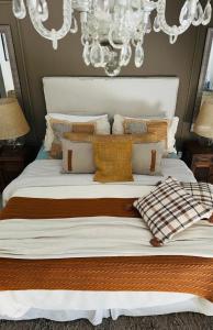a large white bed with pillows and a chandelier at Casa Carite in Ocean Park