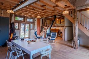 a room with a table and chairs and a staircase at L'arbres aux minutes in Saint-Martin-Sepert
