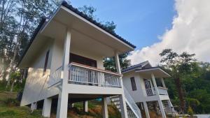 a white house with a balcony and trees at Koh Mook The Home in Ko Muk