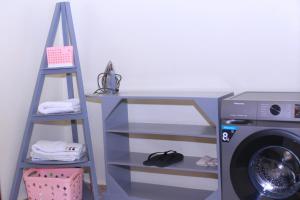 a laundry room with a washing machine and a ladder at Tasha's suites in Entebbe