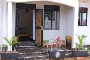 an open door of a house with potted plants at Tasha's suites in Entebbe