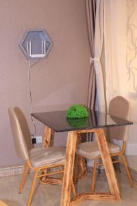 a dining room table with chairs and a lamp at Tasha's suites in Entebbe