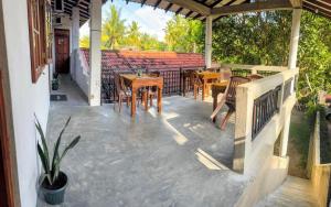 a porch with tables and chairs on a patio at Sanithu Homestay and villa Galle in Galle