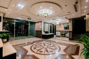 a lobby with a large room with a clock on the floor at Alraya Homes by Betu former Times Inn in Abu Dhabi