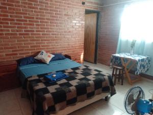 une chambre avec un mur de briques, un lit et une table dans l'établissement Pura Vida, à Cortaderas