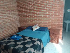 une chambre avec un mur de briques et un lit dans l'établissement Pura Vida, à Cortaderas