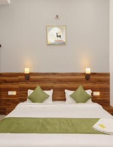 a bedroom with two beds with green and white pillows at The Silverkey Hospitalilty - Krishiv palace Hotel in Vrindāvan