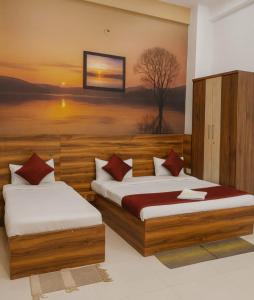 two beds in a room with a painting on the wall at The Silverkey Hospitalilty - Krishiv palace Hotel in Vrindāvan