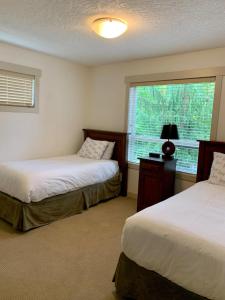 a bedroom with two beds and a window at Sooke Harbour Hideaway - Luxurious Vacation Rental in Sooke