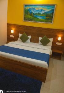 a bedroom with a large bed with a painting on the wall at The Silverkey Hospitalilty - Krishiv palace Hotel in Vrindāvan +6 photos