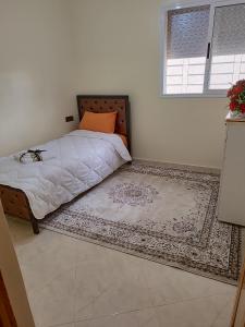 a bedroom with a bed and a rug on the floor at Relaxnstay4 in Midelt
