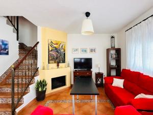 マサゴンにあるCasa FANDANGO Pinar y Marの赤いソファとテレビのあるリビングルーム