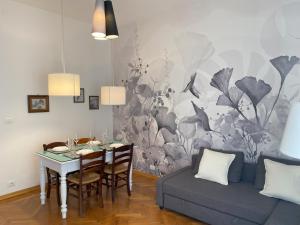 een eetkamer met een tafel en een bank bij Malmusi Apartment in Modena