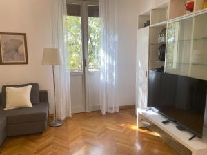 een woonkamer met een flatscreen-tv en een bank bij Malmusi Apartment in Modena