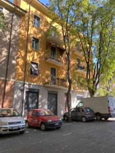 een groep auto's geparkeerd op een parkeerplaats voor een gebouw bij Malmusi Apartment in Modena