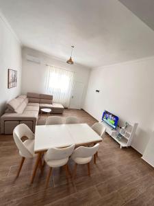 a living room with a table and chairs and a couch at Villa 2211 Berat in Uznovë