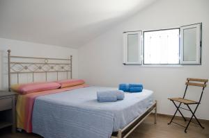 ein Schlafzimmer mit einem Bett und einem Stuhl und einem Fenster in der Unterkunft Villa Chiara in Pozzallo + 57 Fotos