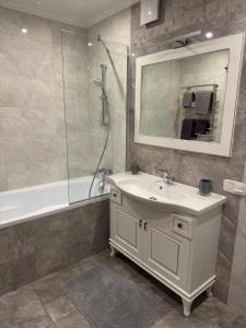a bathroom with a sink and a shower and a mirror at 2к люкс в класичному стилі Netflix in Khmelʼnytsʼkyy +14 photos
