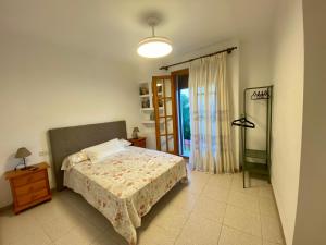 a bedroom with a bed and a lamp and a window at Caminito del Rey casa rural Bellavista Carratraca in Carratraca