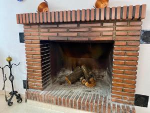 a brick fireplace with logs in it at Caminito del Rey casa rural Bellavista Carratraca in Carratraca +67 photos