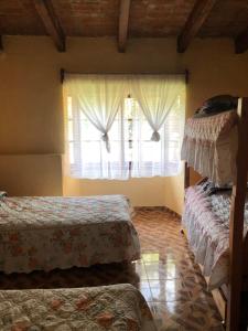 a bedroom with two beds and a window at villa de descanso y convivió familiar en Nepantla in Nepantla de Sor Juana Inés de la Cruz