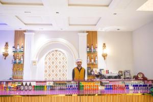 a man standing behind the counter of a bar at Hotel Grand Suites in Multan +18 photos
