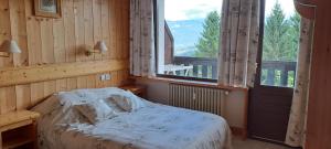 ein Schlafzimmer mit einem Bett und einem großen Fenster in der Unterkunft AP-37 La Grande Cordée Combloux in Combloux