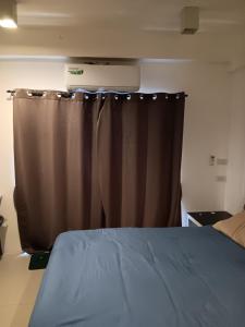 1 dormitorio con cama y cortina marrón en Studio Apartment, en Pattaya central