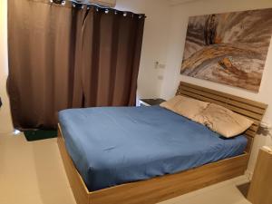 1 dormitorio pequeño con 1 cama con sábanas azules en Studio Apartment, en Pattaya central
