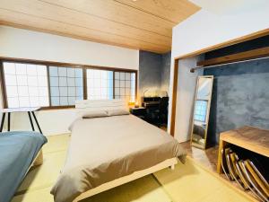 a bedroom with a bed and a desk and windows at Stay Narimasu - 3rooms Apartment, 4min to Narimasu station, 1min to Donki in Tokyo