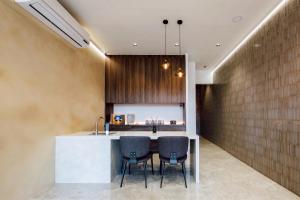 a kitchen with a counter with chairs and a sink at Zhuzhu Light Hotel in Zhushan