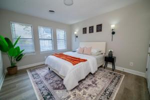 1 dormitorio con 1 cama blanca grande y 1 alfombra en Uptown LUXE Retreat with Parking & Walk to City Center, en Charlotte