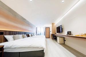 a bedroom with a large bed and a kitchen at Zhuzhu Light Hotel in Zhushan