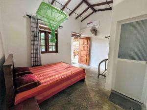 a bedroom with a bed in a room with a window at Sanithu Homestay and villa Galle in Galle
