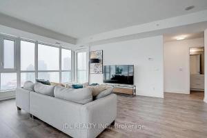 un soggiorno bianco con un divano e una TV di Monville Suites - Downtown Toronto - CN Tower & Rogers Centre a Toronto