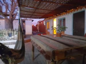 a table and hammock in a room with a tree at La Casa EcoExplor in San Pedro de Atacama