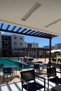 een patio met stoelen en tafels en een zwembad bij Apartamento moderno e aconchegante in Juazeiro do Norte