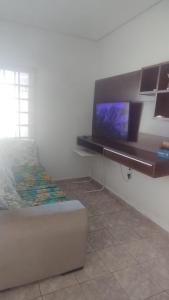 a room with a bed and a tv on a wall at Quarto Conjugado in Itajubá