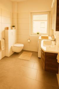 a white bathroom with a toilet and a sink at Wohnen am See in Zernsdorf +11 photos