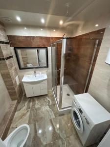 a bathroom with a shower and a toilet and a sink at Двохкімнатна квартира біля моря in Chornomorsk