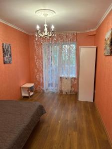 a bedroom with orange walls and a bed and a window at Двохкімнатна квартира біля моря in Chornomorsk