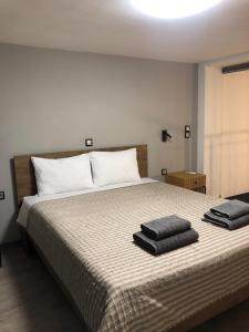 a bedroom with a bed with two towels on it at Loft of e-smile in Thessaloniki