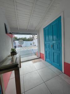 a room with a blue door and a tile floor at Beira Mar Hostal Buzios in Búzios