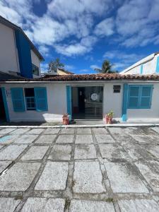 a white and blue house with blue shutters at Beira Mar Hostal Buzios in Búzios