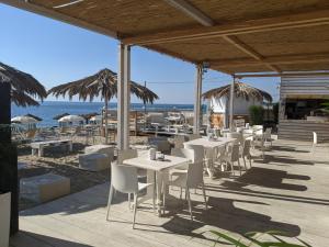 a restaurant with tables and chairs on the beach at Riva di Davoli One Bedroom Apartment in Marina di Davoli