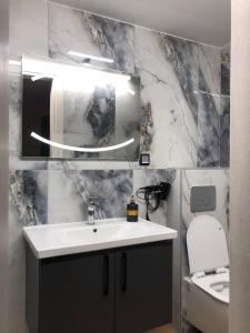 a bathroom with a sink and a mirror and a toilet at Loft of e-smile in Thessaloniki +60 photos
